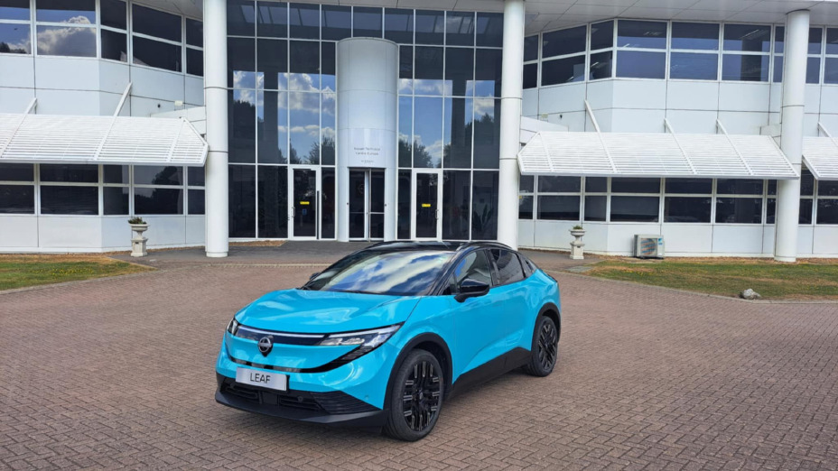 Blauwe Nissan LEAF driekwart voor, geparkeerd voor een gebouw