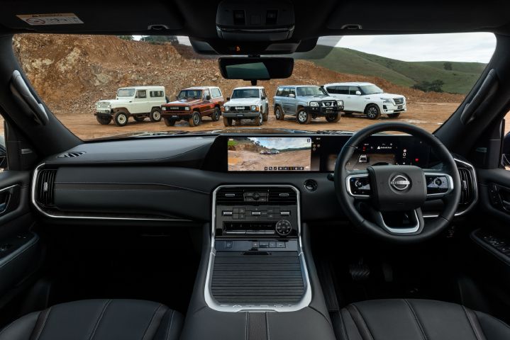 A wide dash shot from within the all-new Nissan Patrol showing a line-up of previous generations parked outside.
