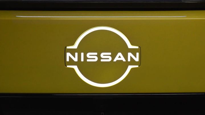 Close-up of an illuminated Nissan badge on a yellow car