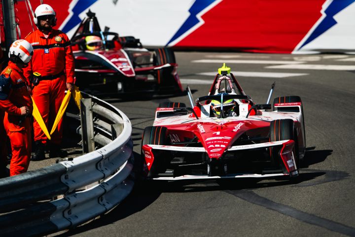 Oliver Rowland biegt im Nissan Formula  E Rennwagen mit der Startnummer 1 beim E-Prix von Monaco nach rechts in eine Kurve ein, während sich Streckenposten auf der Innenseite der Absperrung befinden.