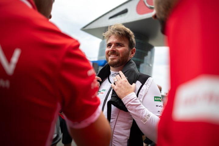 Oliver Rowland mit einem Lächeln vor dem E-Prix in Shanghai, in seinem weißen Unterhemd und mit einem Handtuch um den Hals.
