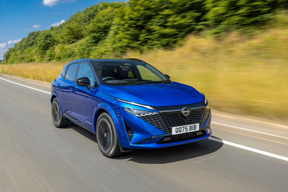 Front three quarter image of a blue Nissan Qashqai driving at speed along a rural road