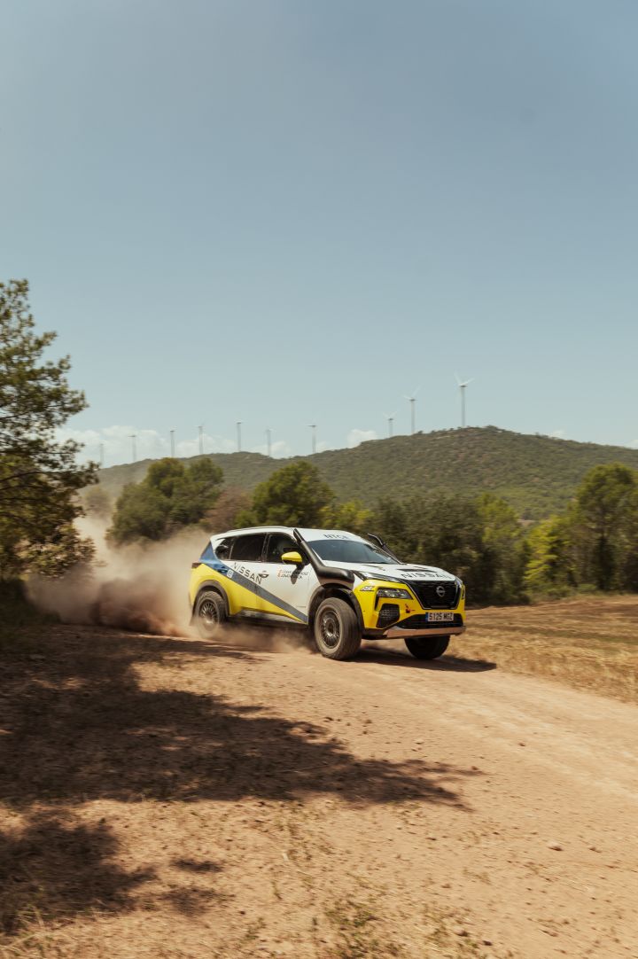 Fahraufnahme des Nissan X‑Trail Rennwagens während der Baja Aragon Rallye 2024, das Auto driftet um eine Kurve und wirbelt dabei Sand auf