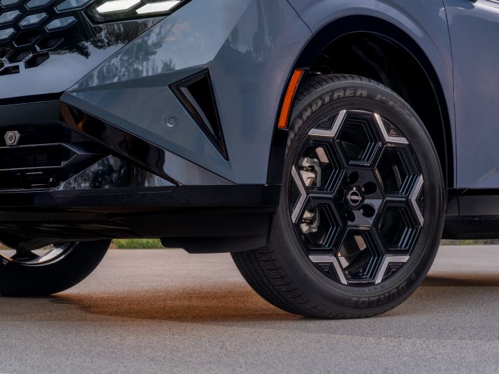 精巧な幾何学パターンを採用した19インチホイールを備える新型日産ローグ ハイブリッド プラチナム。走行時には光と影が織りなす印象的な表情を見せる。