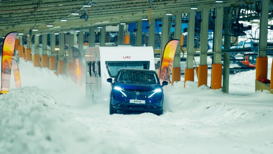 Nissan Ariya met caravan in de sneeuw raast de skihelling op