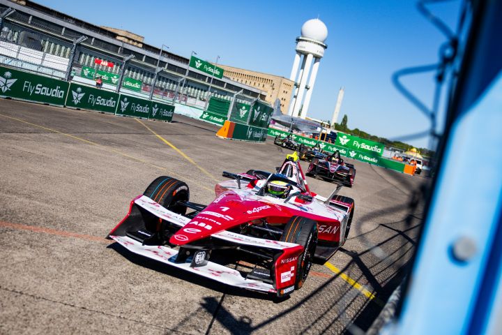 Frontalaufnahme von Oliver Rowland im Nissan Formula E Rennwagen mit der Startnummer 1 auf der Rennstrecke in Berlin, hinter ihm mehrere andere Autos.