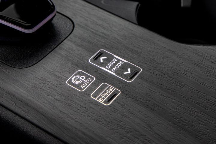Detailaufnahme der ins Holz integrierten Tasten zur Fahrmodus- und e‑Pedal-Auswahl auf der Mittelkonsole im Nissan Ariya