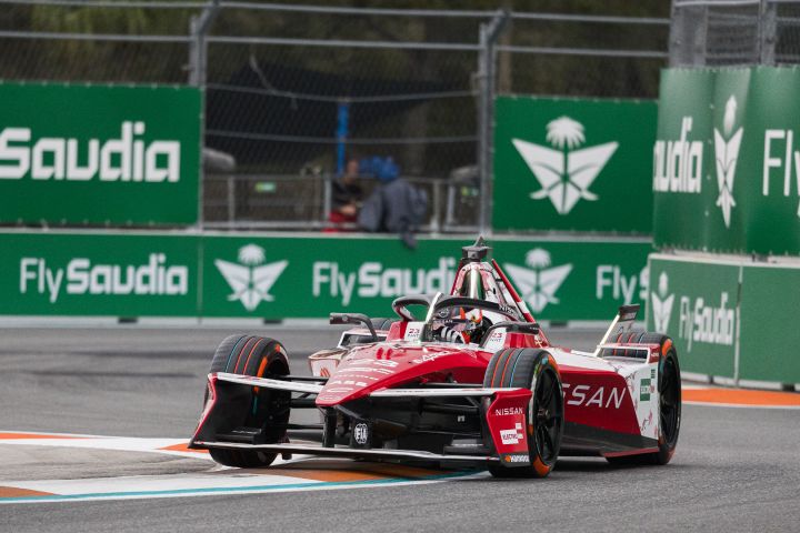 Frontalaufnahme von Norman Nato im Nissan e‑4ORCE 05 mit der Startnummer 23 auf der Rennstrecke des Miami International Autodrome, im Hintergrund sind grüne Werbetafeln zu sehen.