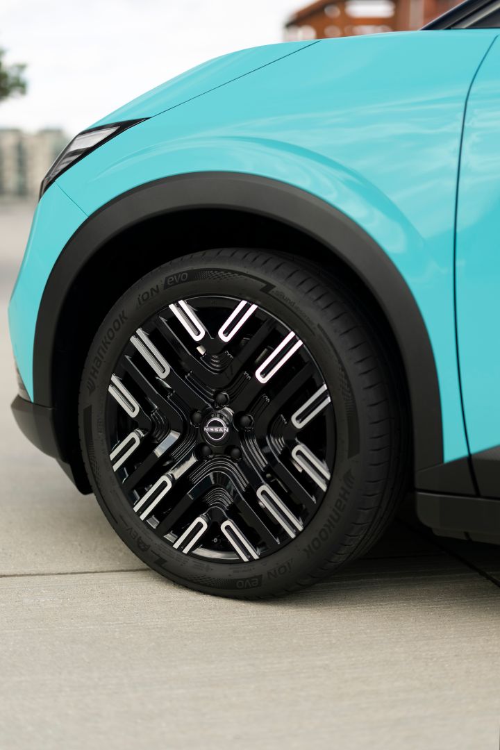 Nahaufnahme der Frontpartie eines türkisen Nissan LEAF mit schwarzen Leichtmetallfelgen