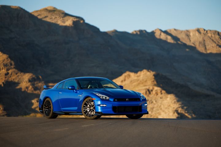 Blue 2024 Nissan GT‑R Special Edition parked on a road with a mountain in shadows in the background