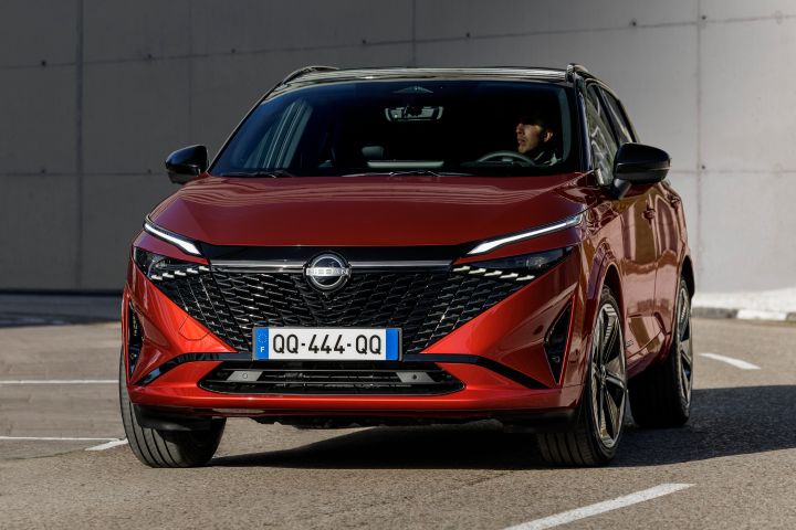 Nissan Qashqai rouge Fuji de face garé sur une place de parking