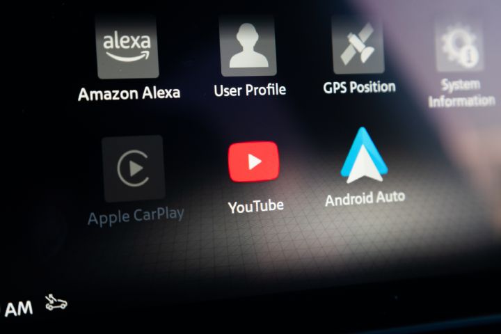 Close-up of the Nissan X‑Trail infotainment touchscreen, displaying connected services and smartphone integration apps including Amazon Alexa, Apple CarPlay, YouTube and Android Auto.