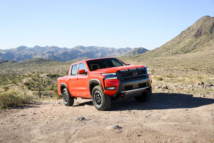 Front right 3.4 view of a Nissan frontier parked on a rocky hill.