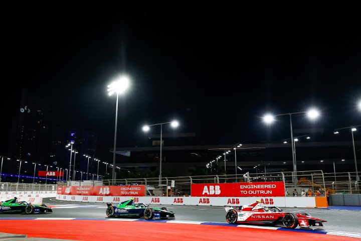 Seitenansicht von Oliver Rowland, der mit seinem Nissan Formel E Rennwagen unter den Flutlichtern auf der Rennstrecke von Dschiddah fährt