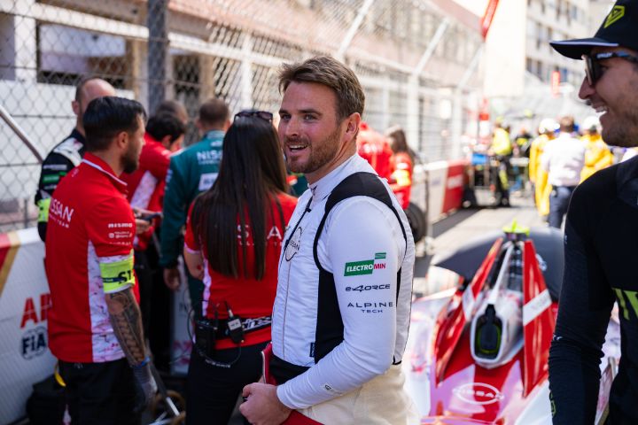 Oliver Rowland lächelt in seinem weißen Nissan Shirt in der Startaufstellung.