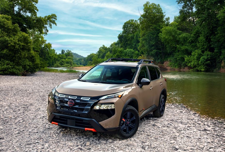 Front left 3/4 view of the 2027 Nissan Rogue Rock Creek parked on the edge of a river.