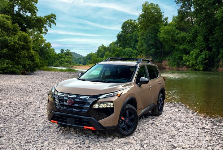 Front left 3/4 view of the 2027 Nissan Rogue Rock Creek parked on the edge of a river.