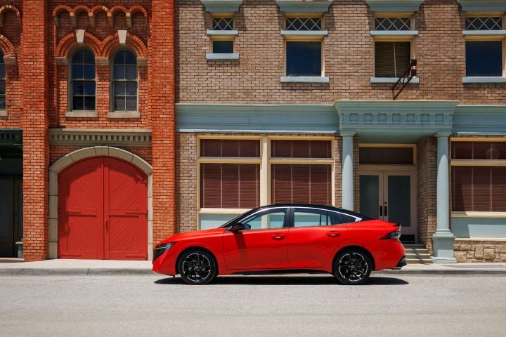 Left profile of the 2026 Nissan Sentra parked in front of city buildings.