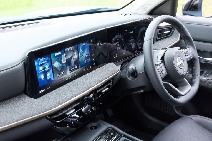 キックスの運転席まわりのインテリア。右ハンドルのステアリングと横長ディスプレイが左から右へ広がる構図で、黒基調のダッシュボードと操作パネルが見える。