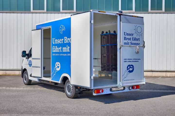 Blick von schräg hintern auf einen Nissan Interstar-e mit Bäckereikoffer mit geöffneter Seitentür und offener Hecktür