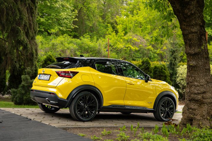 Żółty Nissan Juke (widok z boku) stojący na tle zieleni