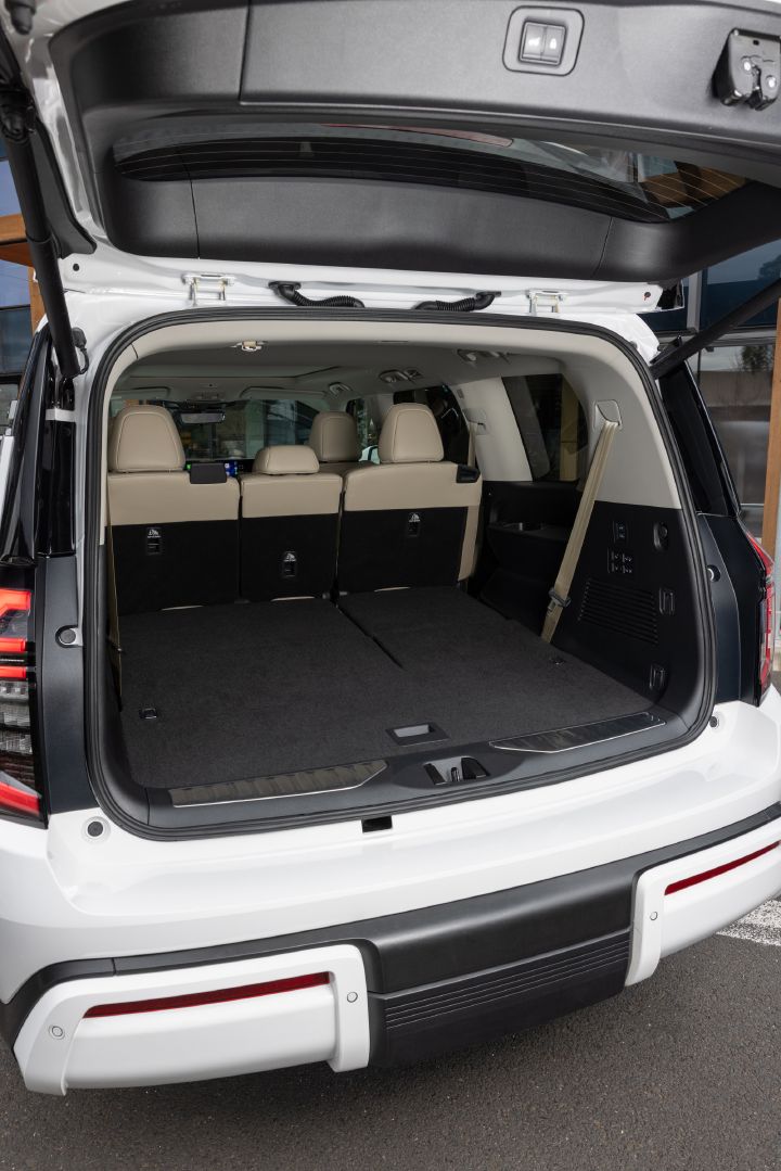 2026 Nissan Y63 Patrol finished in white, rear cargo area shown with the tailgate open, third-row seats folded flat and second-row seats upright to maximise cargo capacity.
