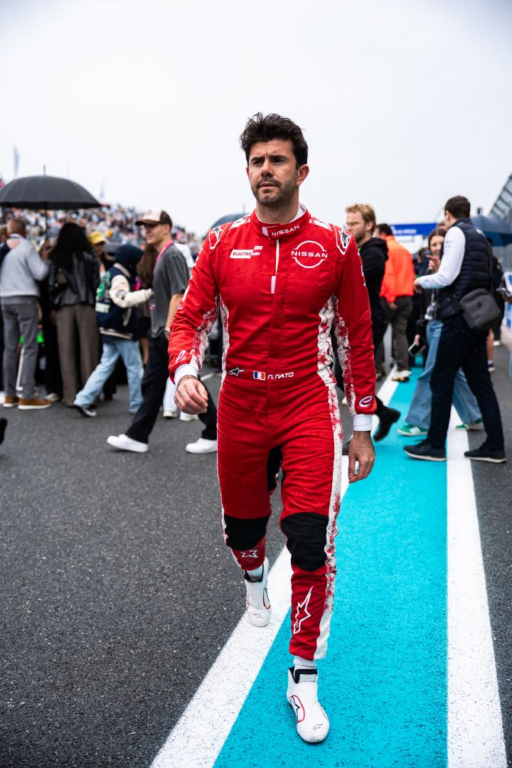 Porträtfoto von Norman Nato in seinem roten Rennanzug des Nissan Formula E Teams, wie er vor dem Miami E-Prix die Boxengasse entlangläuft.