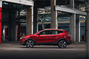 A red Nissan Qashqai parked in a large industrial structure