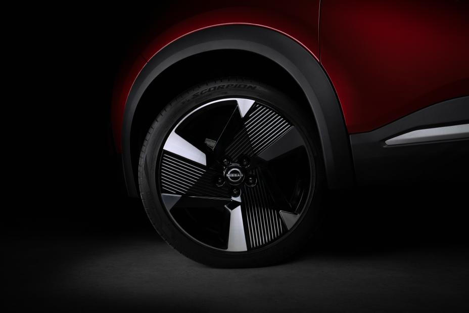 Vista lateral do novo Nissan Kicks destacando a traseira do carro com pintura em vermelho metálico e teto preto. O nome “KICKS” aparece na janela traseira, com linhas aerodinâmicas e estilo arrojado