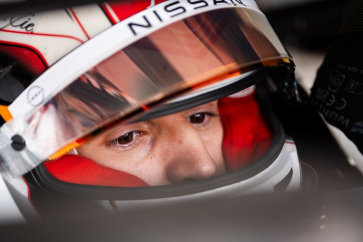 Gabriele Minì mit seinem rot-schwarz-weißen Helm und hochgeklapptem Visier, auf dessen Oberseite teilweise das Nissan-Logo zu sehen ist.