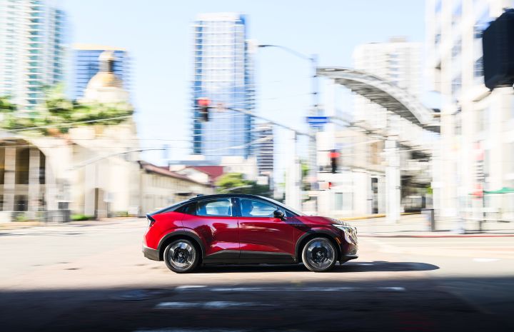 Right profile view of the 2026 Nissan LEAF driving on a city street.