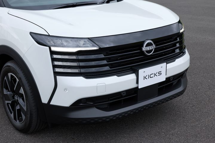 白系キックスのフロント部分のクローズアップ。フロントグリルとヘッドライトが強調され、車両は右向きに配置されている。