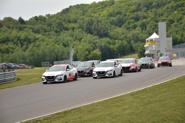 Group of Nissan Sentra Cup cars racing on the track.