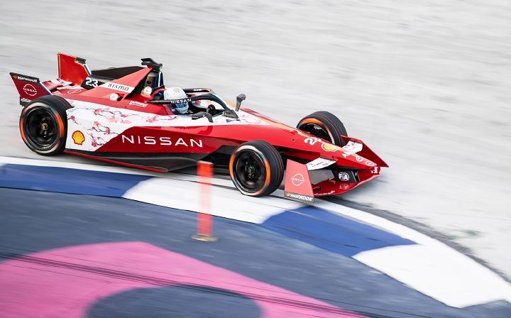 Carro da Equipe Nissan de Fórmula E fazendo curva na pista durante prova do E-Prix