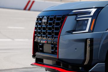 Angled close up of the grill on the 2026 Nissan Armada NISMO, the sun ...