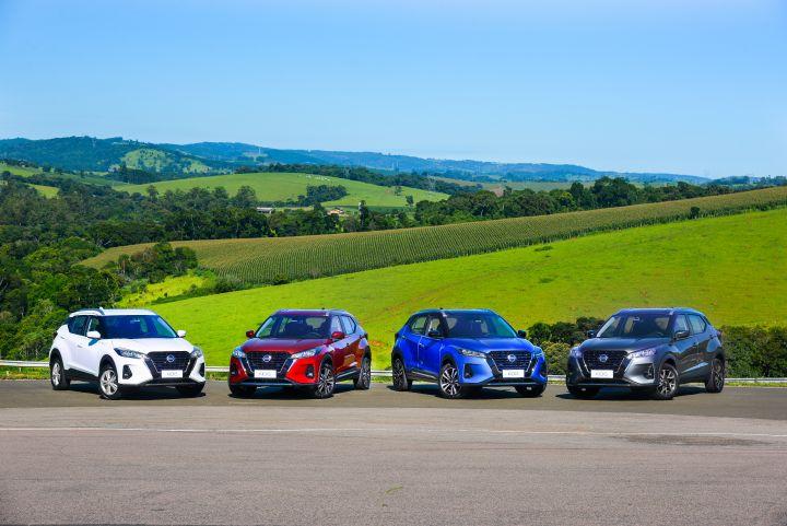 Quatro versões do Nissan Kicks formam um semi-arco em uma pista, posando de frente para a foto