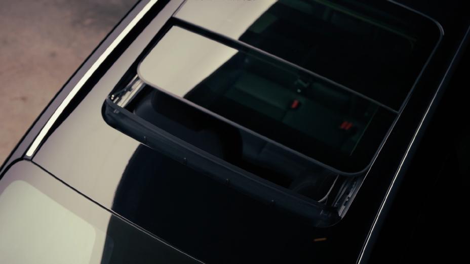 Detalhe do teto solar panorâmico do novo Nissan Kicks, visto parcialmente aberto, destacando o design e o interior do veículo
