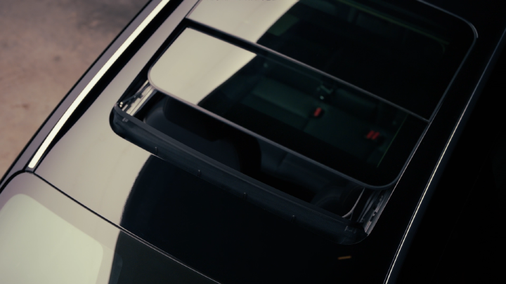 Detalhe do teto solar panorâmico do novo Nissan Kicks, visto parcialmente aberto, destacando o design e o interior do veículo